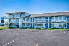 A motel with a two-story structure, a parking lot, and a clear sky. - Studio6 Rosenberg, TX (Rosenberg)