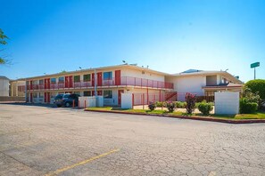 A motel with a two-story structure, a parking lot, and a small garden area. - Days Inn by Wyndham Wichita Falls (Wichita Falls)
