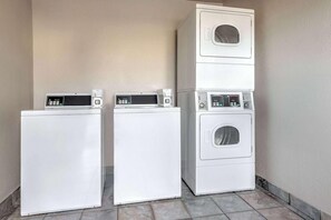 A laundry area with three stacked washing machines. - Days Inn by Wyndham Wichita Falls (Wichita Falls)
