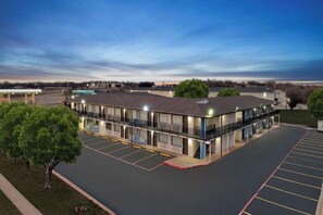 A motel with a parking lot, a covered area, and a building with multiple windows. - Days Inn by Wyndham Wichita Falls (Wichita Falls)
