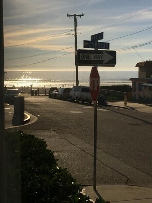 Straatbeeld met stopbord, verkeersbord 'enkelrichting' en een bord met 'Navy Cyprus' tegen een achtergrond van de ondergaande zon.