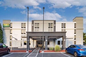 A modern hotel with a covered entrance, a parking lot, and a clear sky. - Wingate by Wyndham Fishkill Hotel (Fishkill)