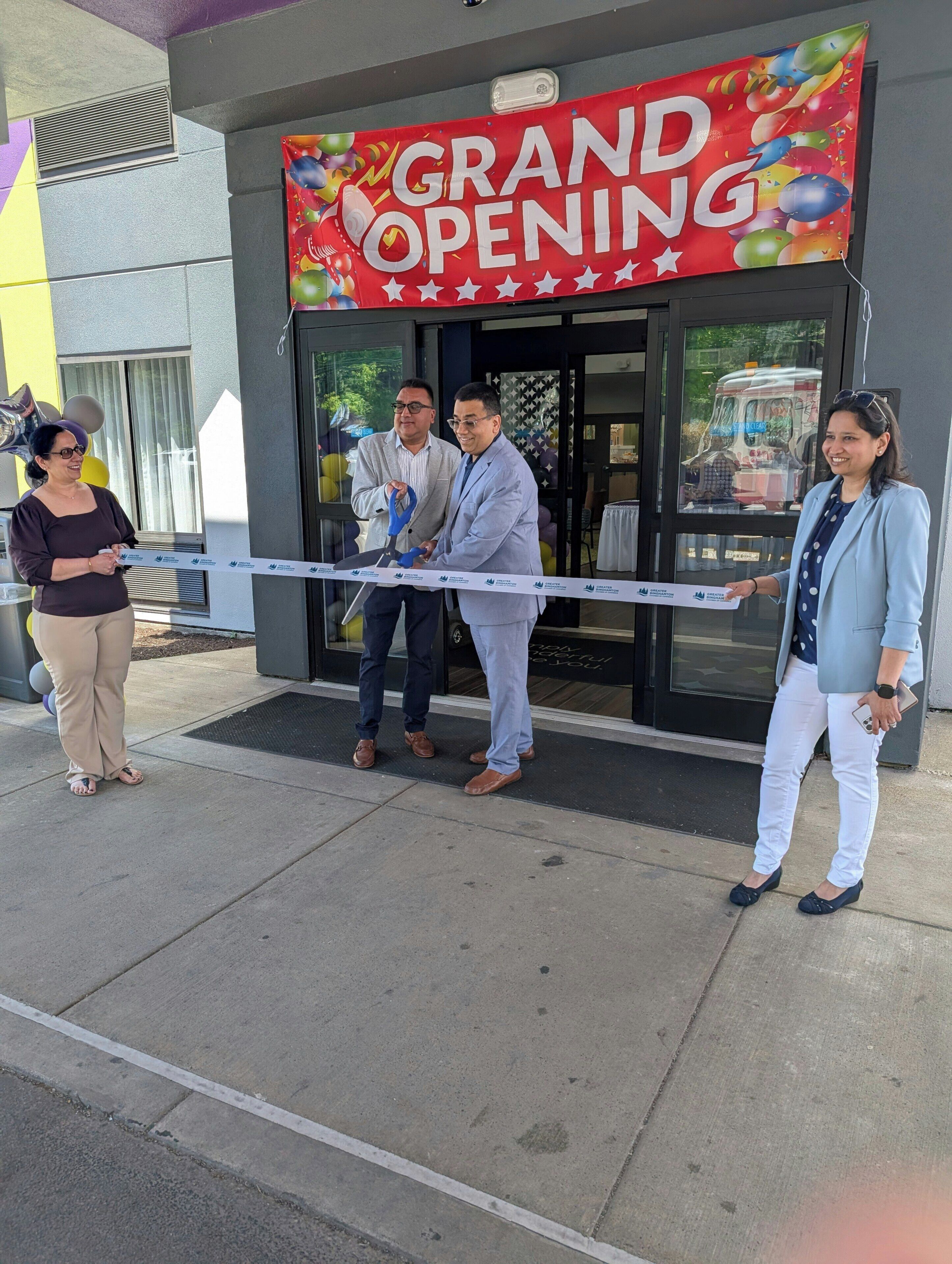A building with a 'GRAND OPENING' banner, a door, and a window.