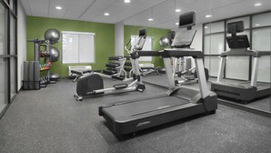 Ein Fitnessstudio mit Laufbändern, Crosstrainern und Kurzhanteln.