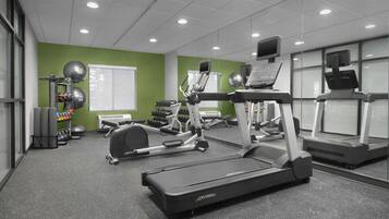 A gym with treadmills, elliptical machines, and free weights.