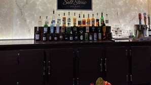 A bar area with a sign reading 'Salt Stone Lounge,' a selection of liquor bottles, and a beer tap.