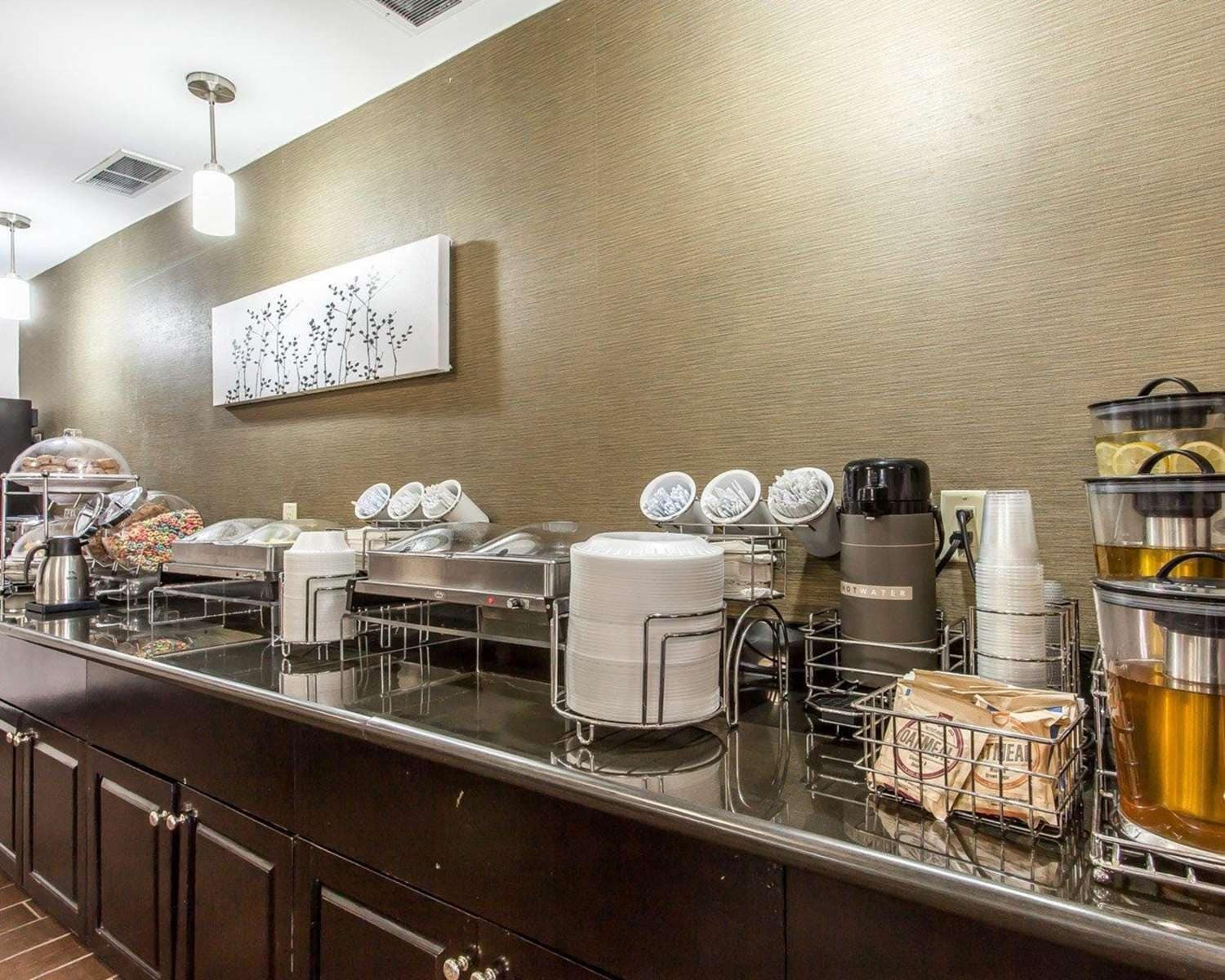 Un comptoir de buffet proposant divers plats, une machine à café et un distributeur d’eau.