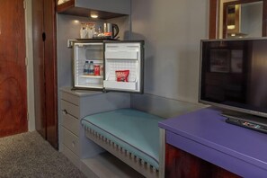 A compact room with a bed, a small seating area, a television, and a refrigerator. - Sheffield City Hotel (Sheffield)