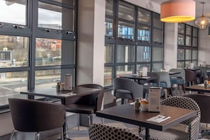 A modern dining area with large windows, tables, and chairs. - Sheffield Metropolitan Hotel by Belvilla (Sheffield)