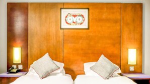 A hotel room with two beds, a wooden headboard, a framed picture, bedside lamps, and a telephone on the nightstand. - Sheffield Metropolitan Hotel by Belvilla (Sheffield)