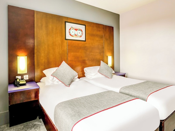 A double bed with white bedding and grey throw blankets, two bedside tables with lamps, a wooden headboard, and a framed picture above the headboard. - Sheffield Metropolitan Hotel by Belvilla (Sheffield)