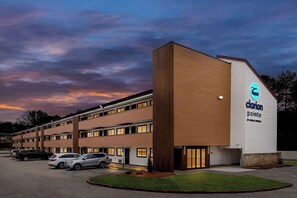 A hotel with a modern design, featuring a prominent logo on the side. - Clarion Pointe Kennesaw Town Center (Kennesaw)