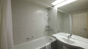 Un baño con bañera, lavamanos y ducha.