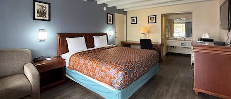 Een hotelkamer met een bed, een bureau, een stoel en een televisie.