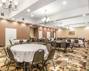 A conference room with round tables, chairs, chandeliers, and a patterned carpet. - Red Roof Inn and Suites Longview (Longview)