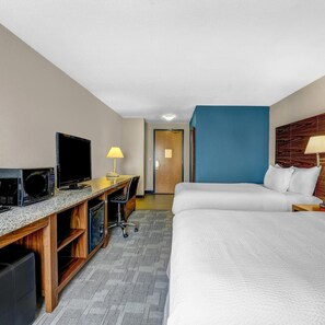 A hotel room with a bed, a desk with a computer and a TV, a lamp, and a door. - Days Inn Red Deer (Red Deer)