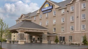 Un hotel Days Inn con un cartello ben visibile, un ingresso coperto e un parcheggio.
