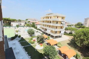 A multi-story residential building with balconies, a tennis court, and outdoor seating areas. - Hotel K2 (Ravenna)
