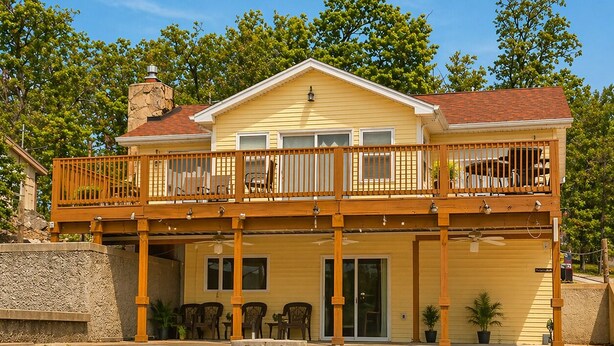 A two-story house with a balcony, a front door, and a staircase leading to the entrance. - Buccaneer Bay #28 - Beachfront Bliss (Sunrise Beach)