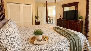 A bedroom with a bed, a ceiling fan, a television, and a dresser. - Buccaneer Bay #28 - Beachfront Bliss (Sunrise Beach)