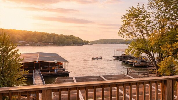 A wooden deck with chairs, overlooking a calm lake with boats and docks. - Buccaneer Bay Resort Cottage #56 (Sunrise Beach)