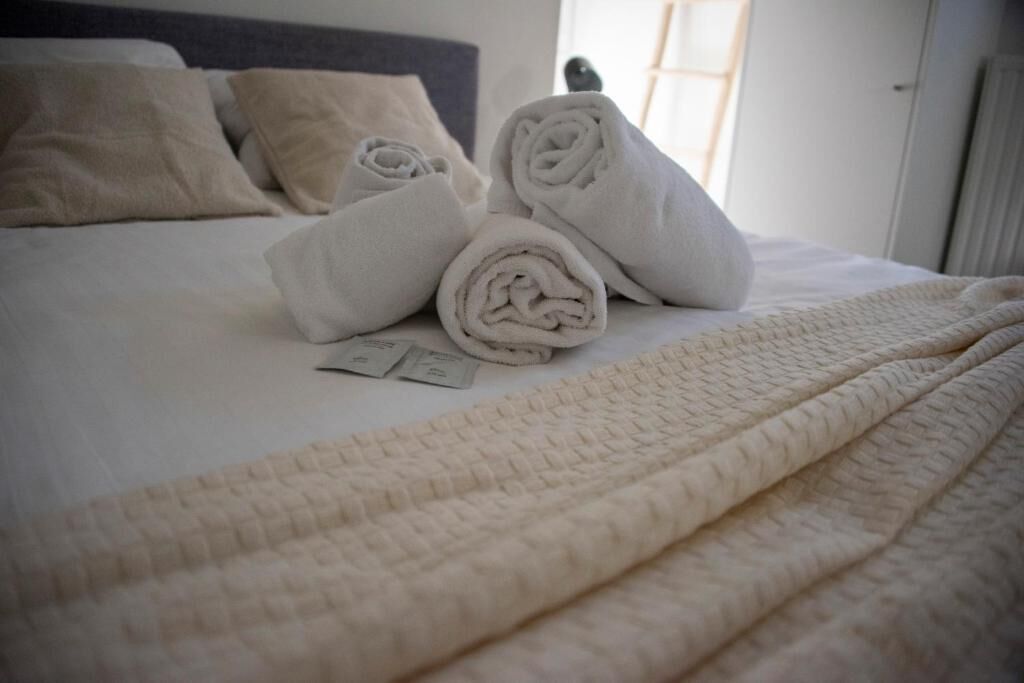 Un letto rifatto con asciugamani arrotolati e una coperta trapuntata.