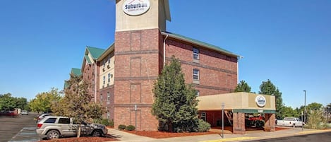 Ein Hotel der Extended-Stay-Klasse in einer Vorstadt, mit Ziegelfassade, einem markanten Turm mit dem Hotelnamen und einem überdachten Eingang.