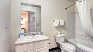 Une salle de bain comprenant un lavabo, des toilettes et un espace douche.