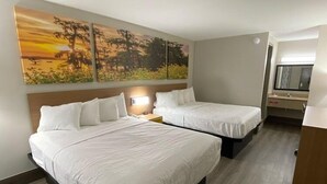 A hotel room with two beds, a nightstand, a desk, and a large painting on the wall. - Days Inn by Wyndham Leeds (Leeds)