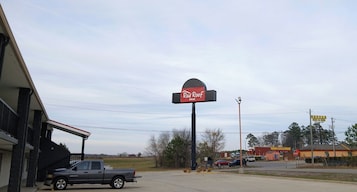 Zona comercial con el letrero de un Red Roof Inn, una Waffle House y una señal de parada.