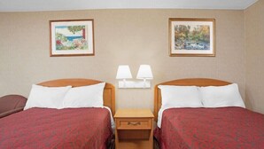 A hotel room with two beds, a nightstand with lamps, and two framed pictures on the wall. - Days Inn by Wyndham Perryville (Perryville)