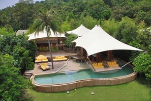 Ein Resort mit Pool, Liegebereich und überdachter Terrasse.