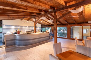 Un espacio interior amplio con techo de madera, barra y asientos.