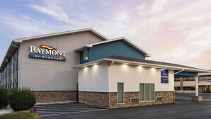 Ein Baymont by Wyndham Hotel mit modernem Design, einem Parkplatz und blauem Himmel.