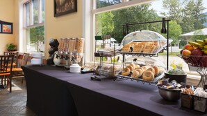 Un buffet de petit-déjeuner proposant une variété d’aliments et offrant une vue sur les arbres à l’extérieur.