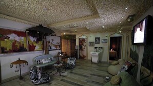 A living room with a patterned ceiling, a sofa, a coffee table, and a television. - 2 Kitarrat Boutique Hotel and Spa (Durrës)