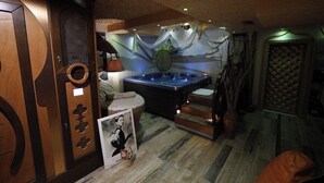 A room with a hot tub, a wooden cabinet, a framed picture, and a patterned wall. - 2 Kitarrat Boutique Hotel and Spa (Durrës)