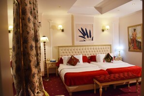 A hotel room with a large bed, two bedside tables, a red carpet, and a painting on the wall. - 2 Kitarrat Boutique Hotel and Spa (Durrës)