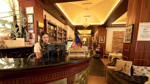 A reception desk with a 'RECEPTION' sign, a flag, and a framed certificate on the wall. - 2 Kitarrat Boutique Hotel and Spa (Durrës)