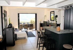 Eine moderne Küche mit Barbereich, einem Essbereich mit Ausblick und einem großen Fenster.