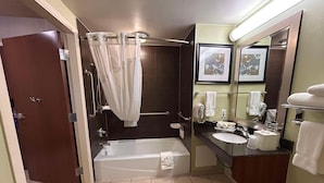 Une salle de bain équipée d’une baignoire, d’une douche, d’un lavabo, d’un miroir et de toilettes.