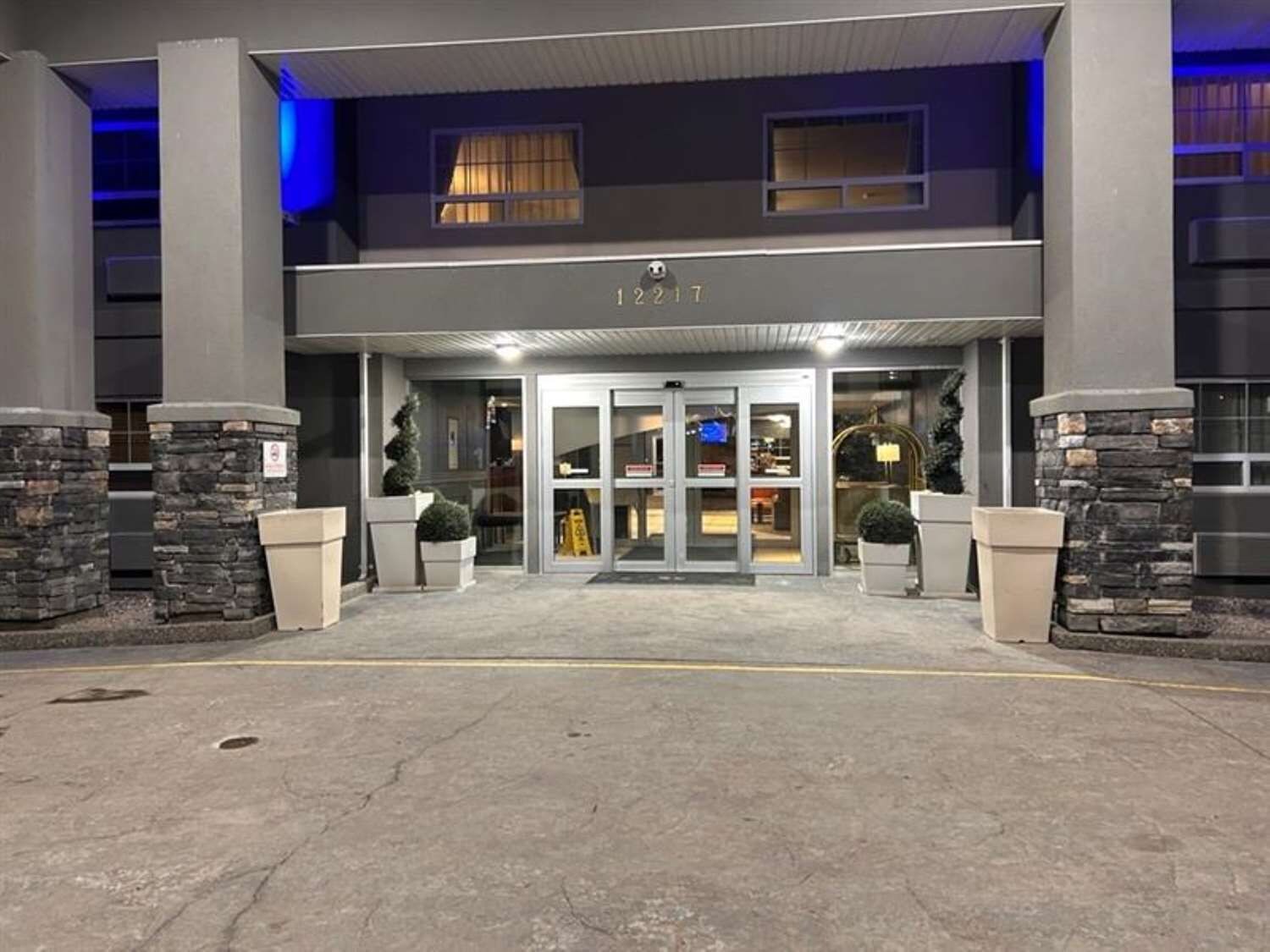 A hotel entrance with a revolving door, stone pillars, and a sign with the number '12217'.