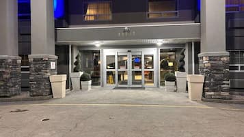 A hotel entrance with a revolving door, stone pillars, and a sign with the number '12217'.