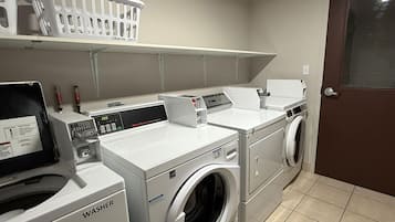 A laundry facility with a front-loading washer, a stacked washer, and a dryer.