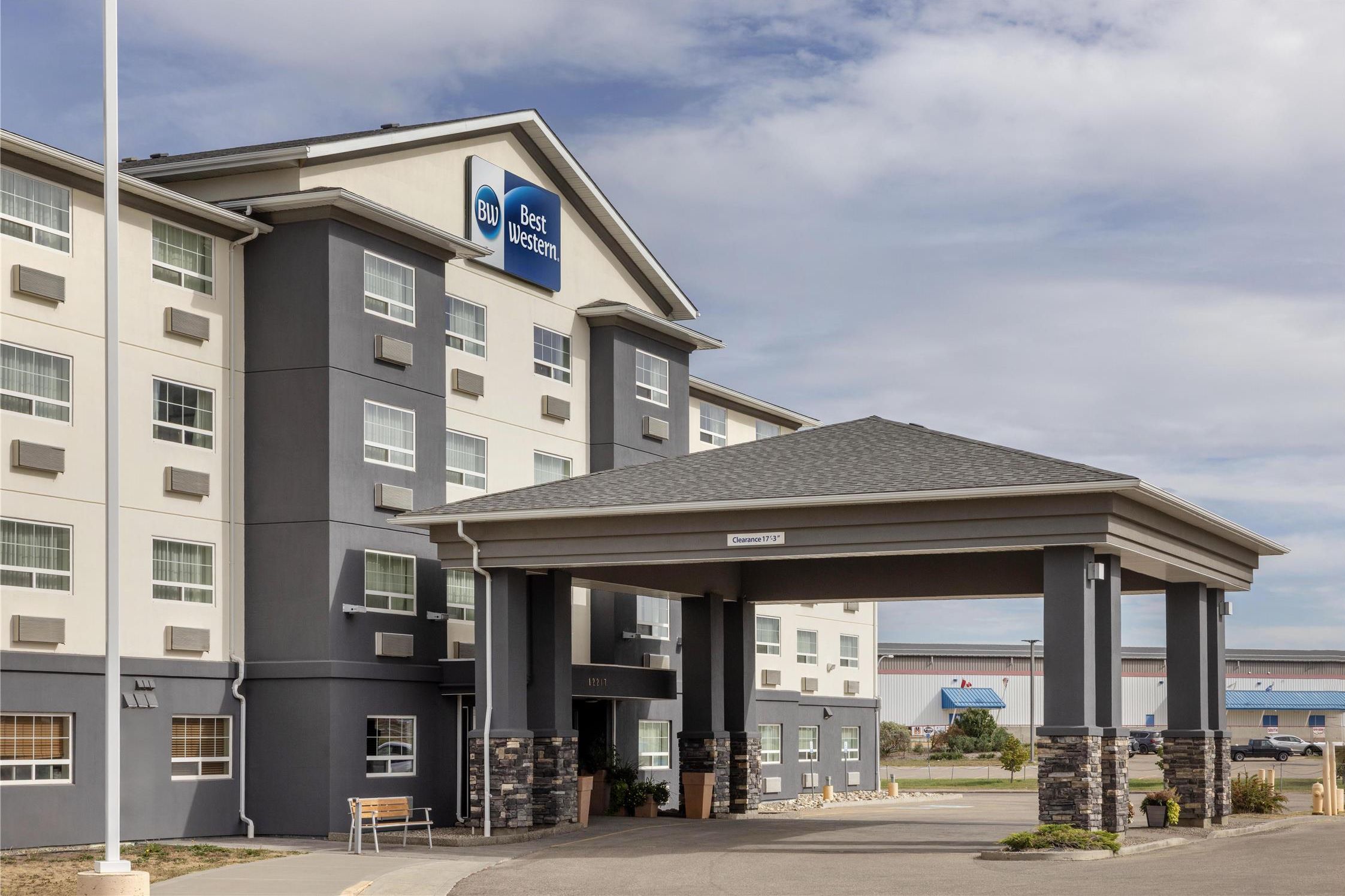 Un hôtel dont l’entrée est bien visible, qui dispose d’un espace d’attente abrité et d’une enseigne indiquant le nom « Best Western ».
