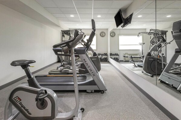 A gym with cardio equipment, weights, and a treadmill.