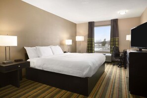 A hotel room with a large bed, two bedside lamps, a desk with a chair, a flat-screen TV, and a window with curtains. - Spark by Hilton Woodstock (Woodstock)