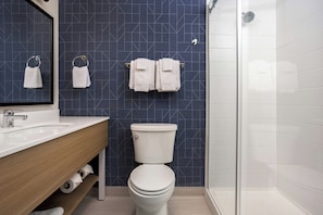 A bathroom with a white sink, a toilet, and a shower. - Spark by Hilton Woodstock (Woodstock)