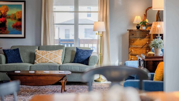 Un salon avec un canapé, une table basse et des lampes.