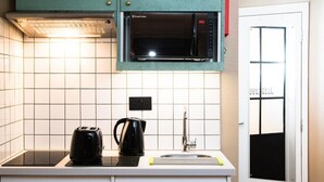A kitchen with a microwave, a kettle, and a sink. - Room2 Hammersmith Hometel (London)